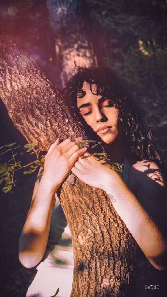 Mujer con los ojos cerrados abrazando el tronco de un árbol, TunaTi