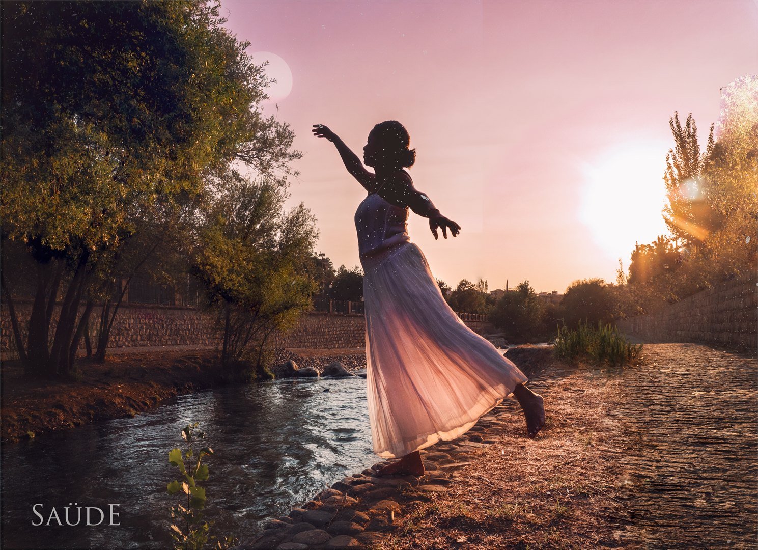 Mujer con vestido blanco bailando junto al río al atardecer, TunaTi