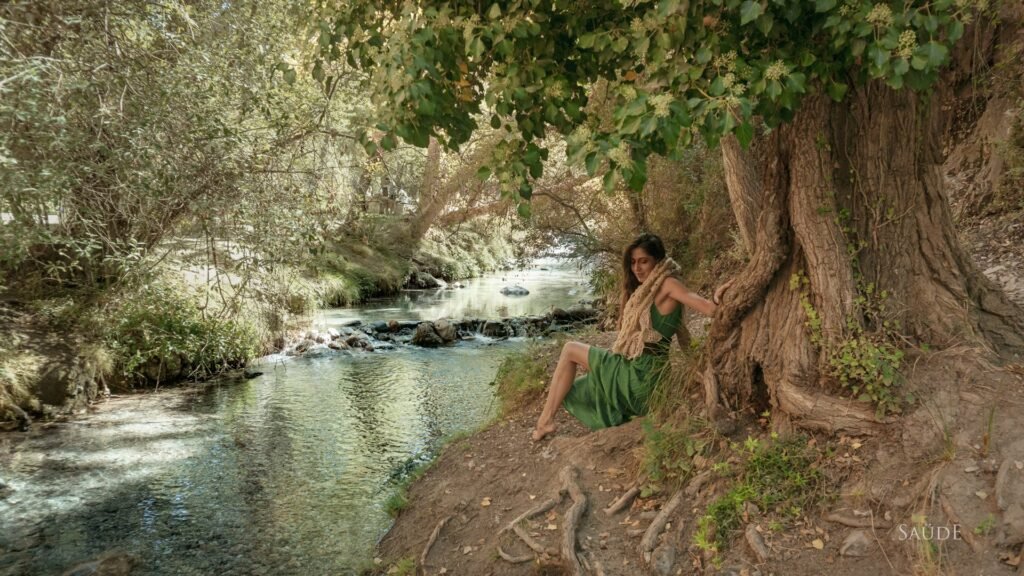 Mujer junto a un gran árbol a la orilla del río, TunaTi