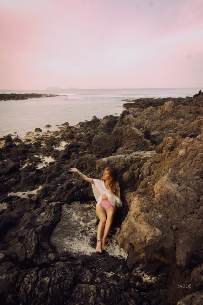 Mujer entre las rocas de la costa al atardecer, TunaTi